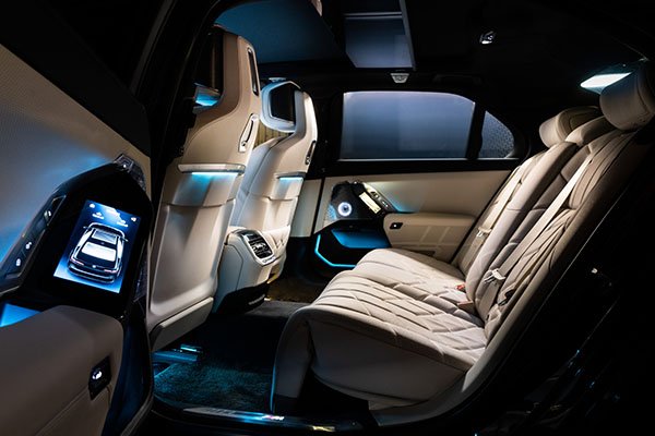 Luxurious rear seating area of the BMW 7 Series with advanced comfort features, perfect for high-end chauffeured travel in London.
