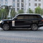 Side profile of a sleek Range Rover, showcasing its elegant design and commanding presence, ideal for business or leisure in London.