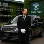 Luxury chauffeur standing beside a black Range Rover at Wimbledon entrance in formal uniform